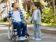 Disabled man in wheelchair with child